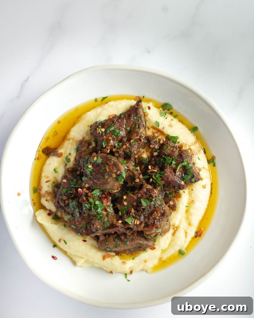 Garlic Infused Butter Mash 6 Garlic butter potato mash served with succulent steak bites, garnished with fresh chives.