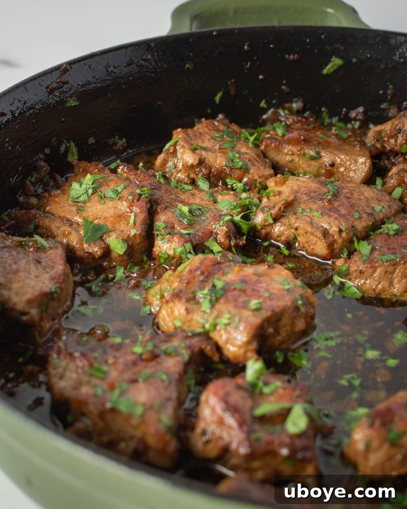 Prepared garlic butter steak bites on a serving platter, garnished with fresh parsley, ready to be enjoyed.
