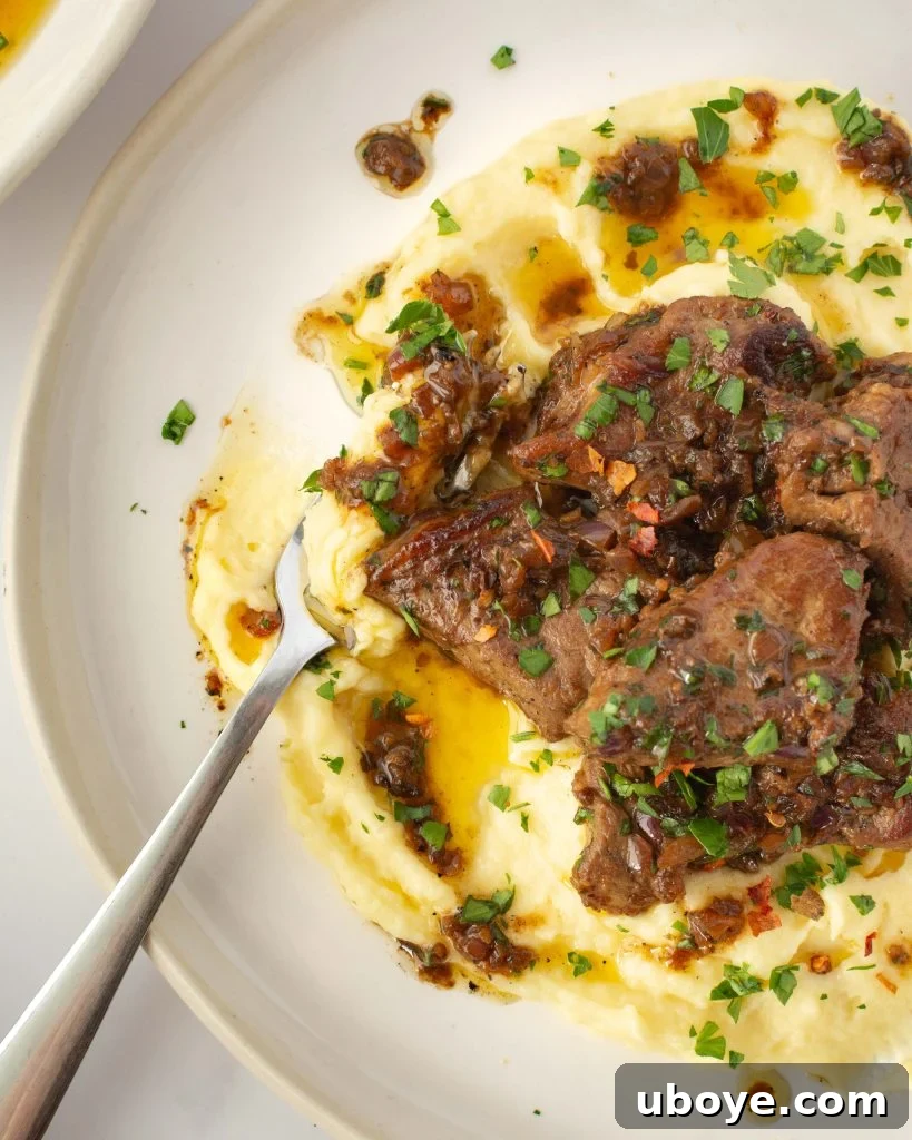 Sizzling garlic butter steak bites cooking in a cast iron skillet, with steam and aroma rising.