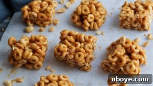 Finished cereal bars neatly sliced and arranged on parchment paper.