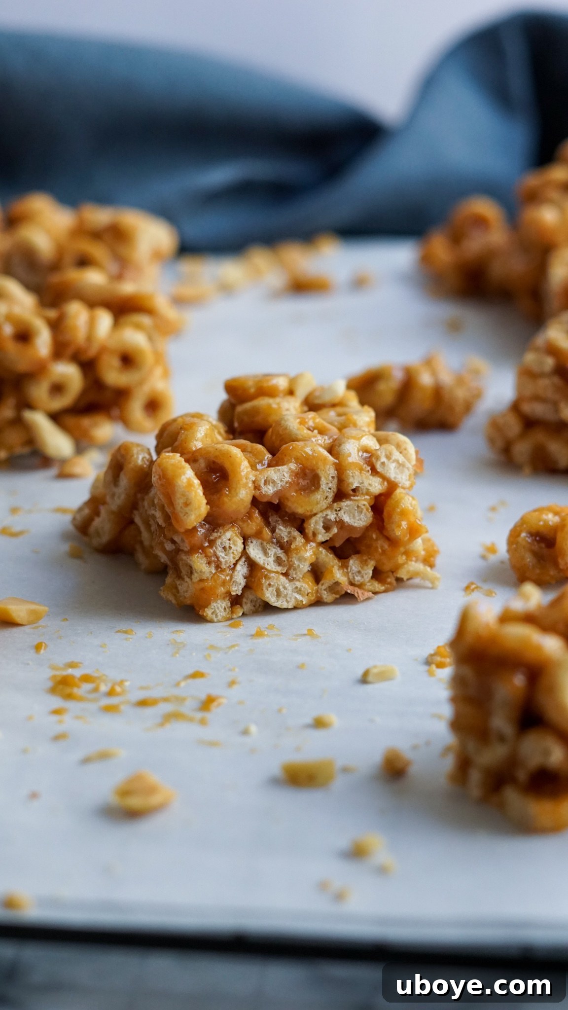 Bee-Free Honey Nut Cereal Bars 3 A batch of golden-brown vegan cereal bars cooling on parchment paper, ready for slicing.