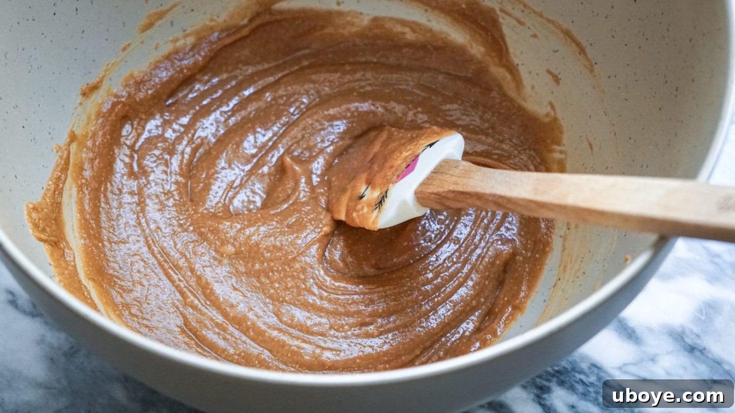 Bee-Free Honey Nut Cereal Bars 6 Close-up of creamy peanut butter, maple syrup, and other ingredients blended smoothly in a mixing bowl.