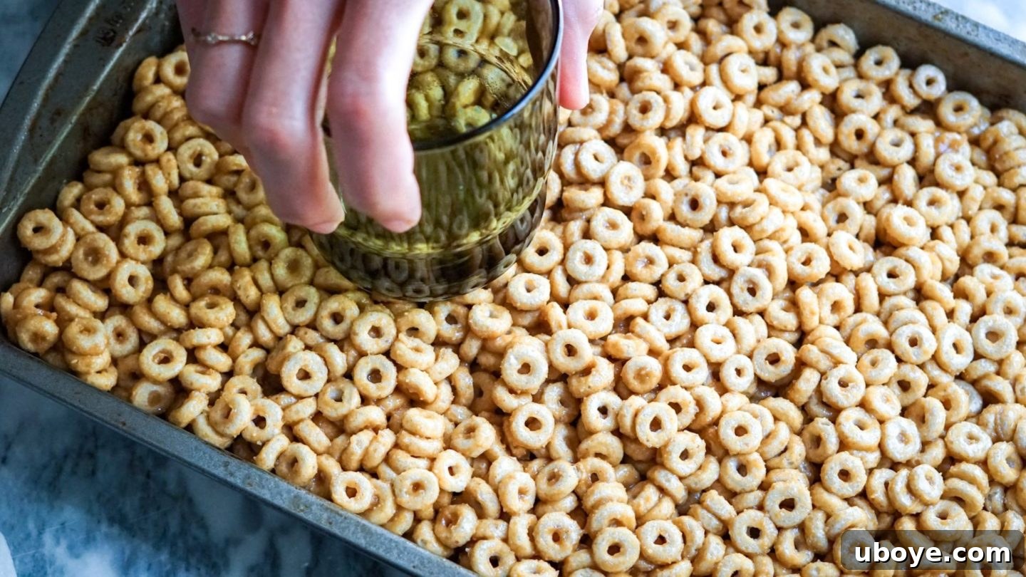 Bee-Free Honey Nut Cereal Bars 8 The cereal bar mixture firmly pressed into a lined 9x9 baking dish, ready for chilling.