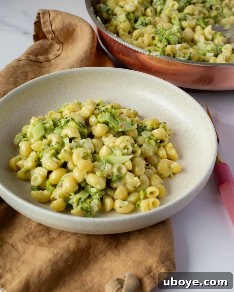 Effortless One-Pot Broccoli Pasta 9 Broccoli pasta served in a white bowl, garnished with fresh herbs and grated cheese