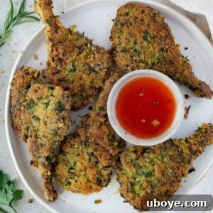 A beautifully arranged serving of crumbed lamb cutlets alongside a bowl of dipping sauce, showcasing the dish.