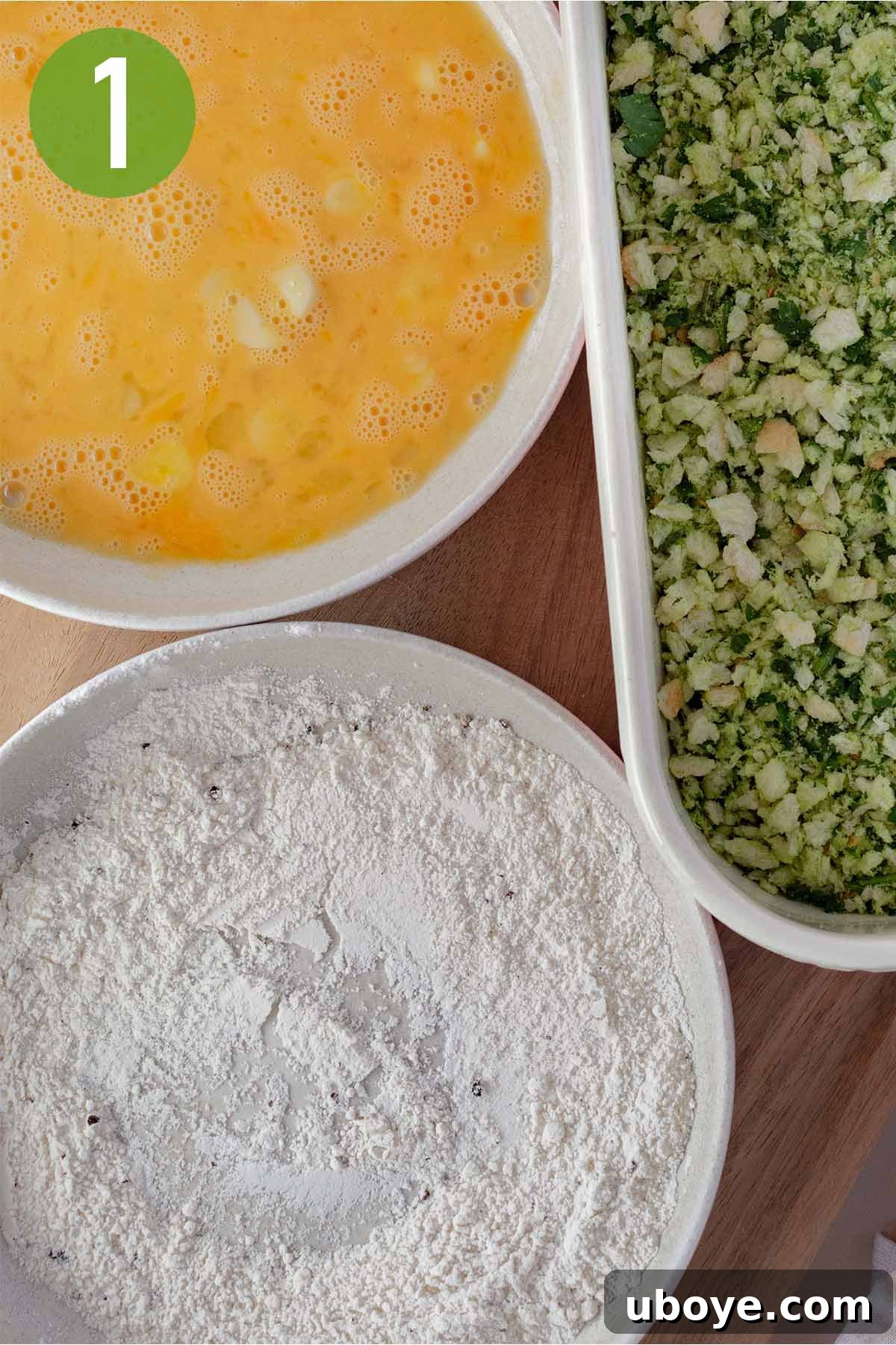 Preparing the breading stations: a bowl of beaten eggs and a bowl of seasoned flour are set up for dredging.