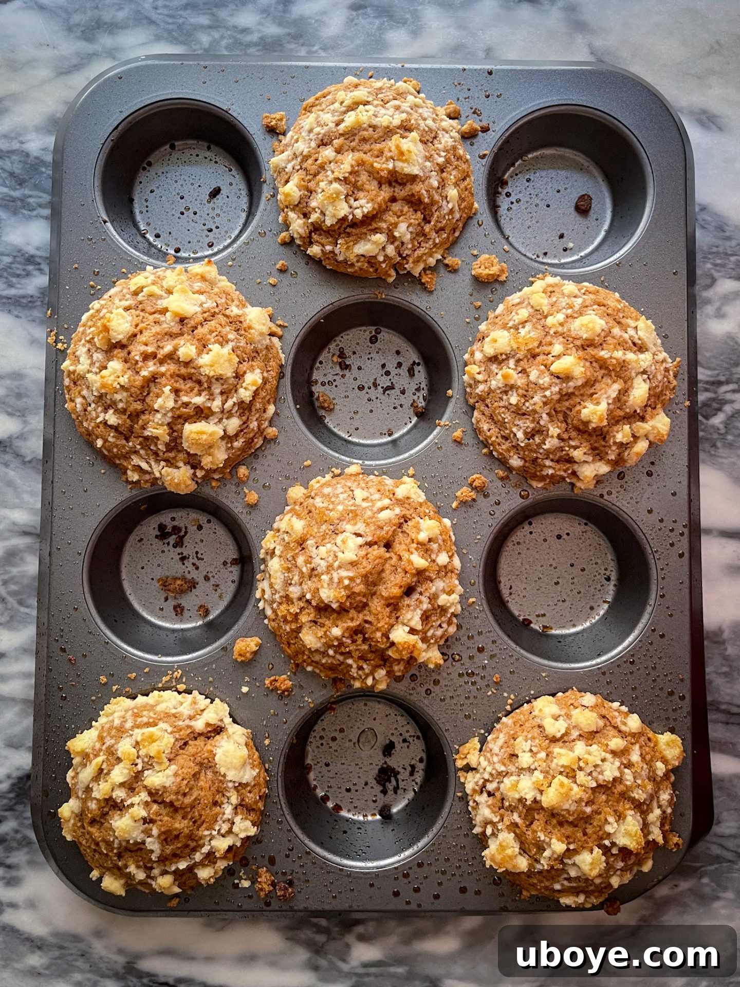 Perfectly baked jumbo vegan apple muffins, golden brown and wonderfully fluffy, resting on a wire rack to cool.