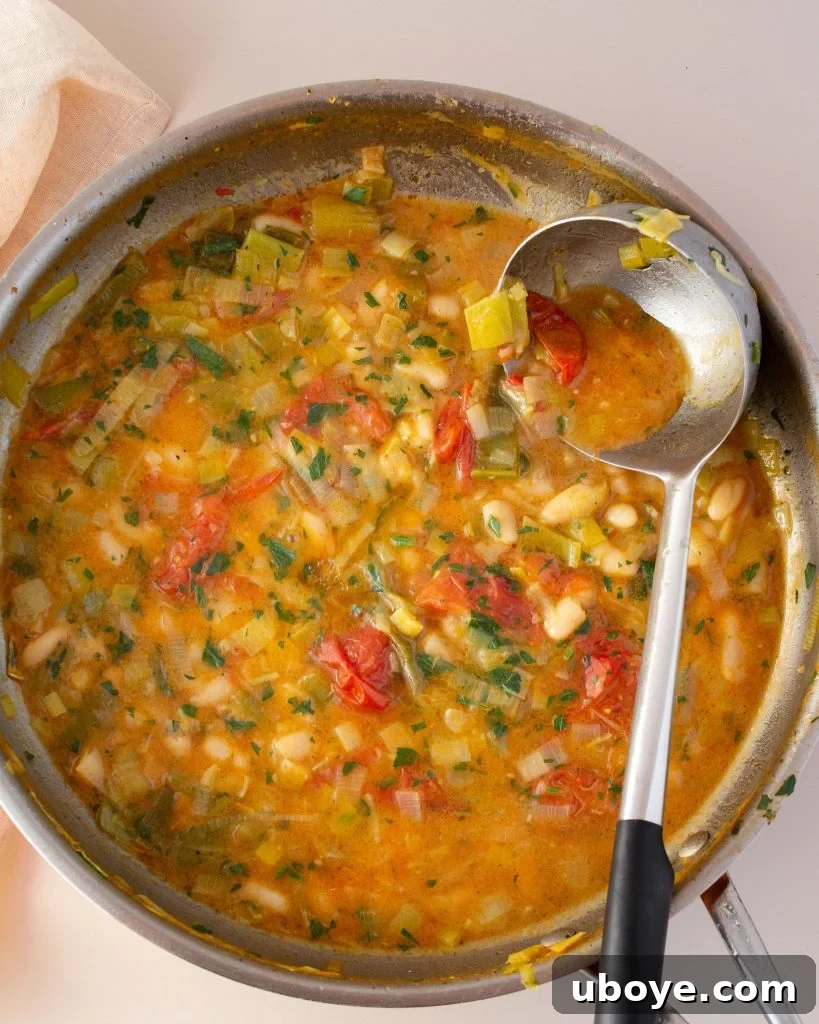 Scooping a spoonful of Lemony Brothy Beans with Scallops