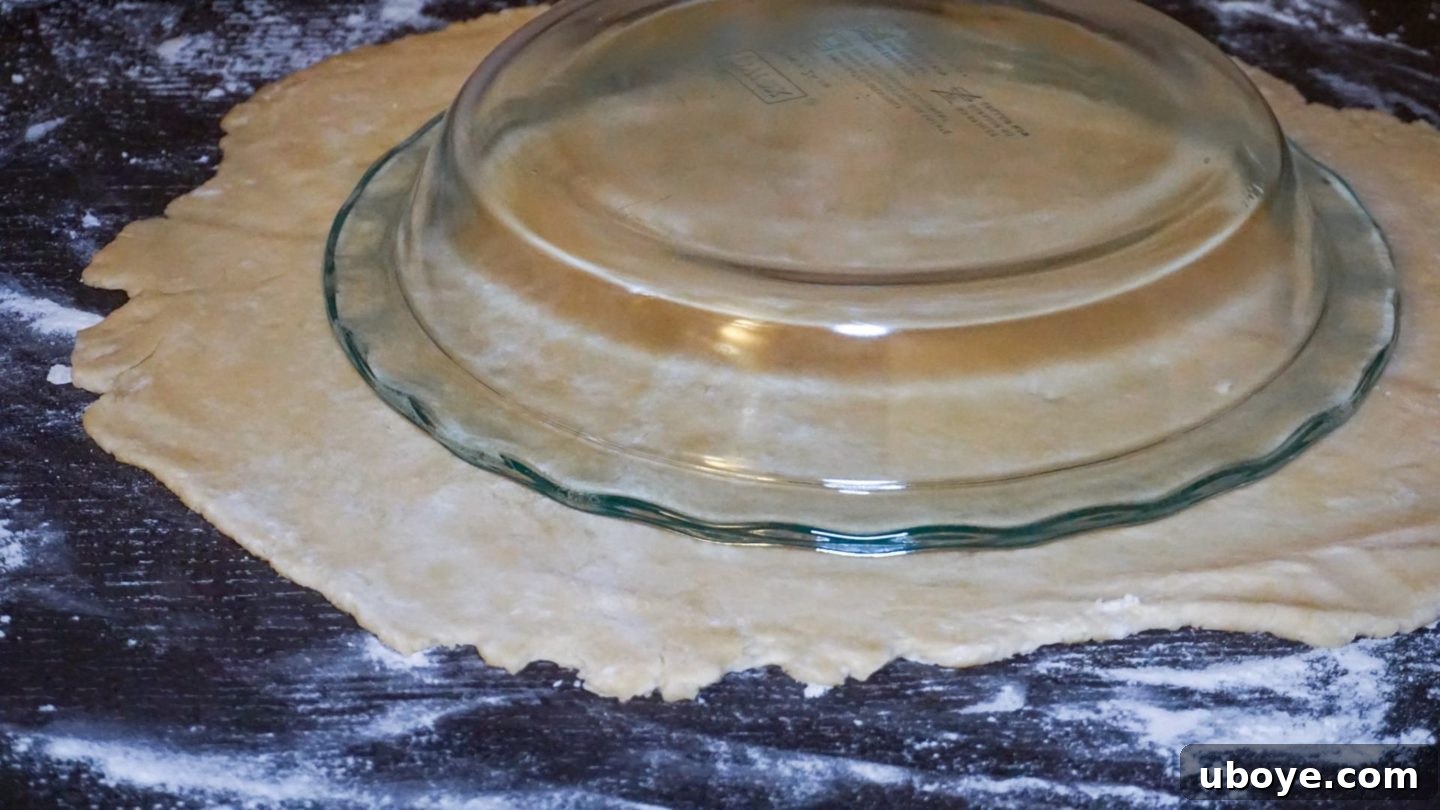 Grandma's Blueberry Comfort 7 A pie plate placed upside down on rolled-out pie dough, demonstrating the ideal amount of overhang needed for a successful crust.