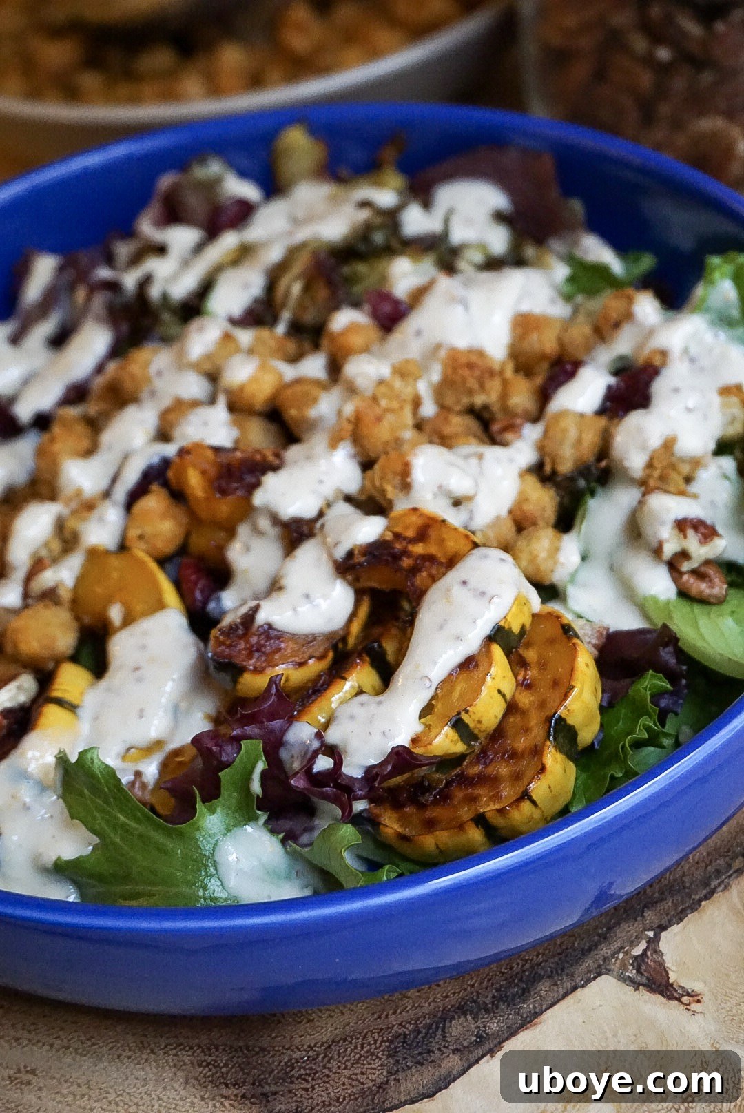 A vibrant and colorful vegan Buddha bowl with various vegetables, grains, and greens, topped with the maple mustard dressing.