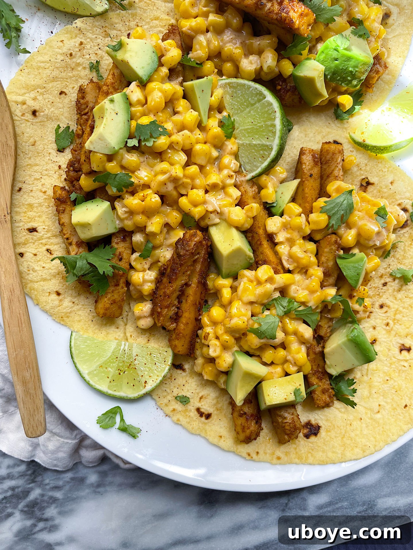 Fiery Elote and Vegan Chick'n Tacos 4 Three vegan chicken and corn tacos on a white plate, with the caption highlighting the 15-minute preparation time.