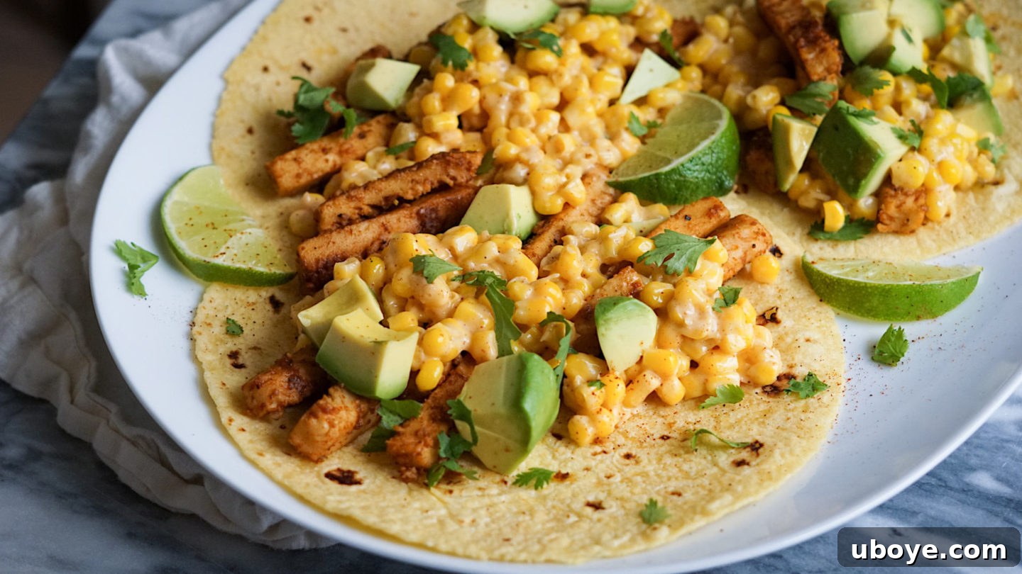 Fiery Elote and Vegan Chick'n Tacos 6 A close-up of a fully assembled vegan chicken and street corn taco on a white plate, with fresh cilantro garnish.