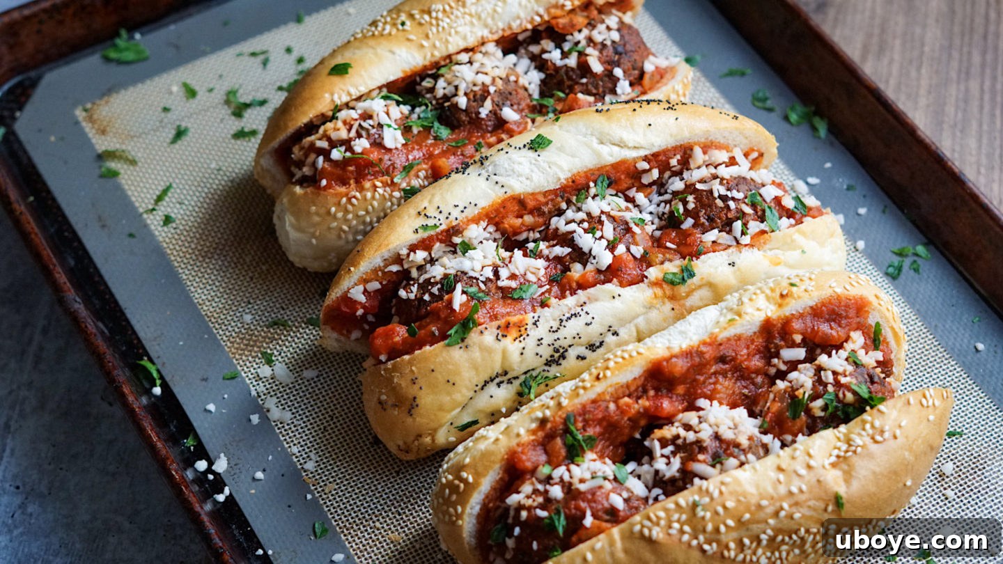 Game-Changing Lentil Meatball Heroes 4 Lentil meatball subs arranged on a baking tray, ready for the oven.