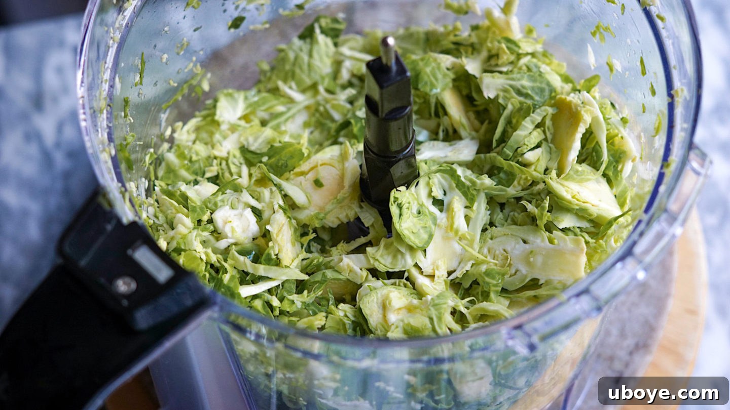 Close-up of finely shredded brussel sprouts sautéing in a pan with tempeh bacon pieces.