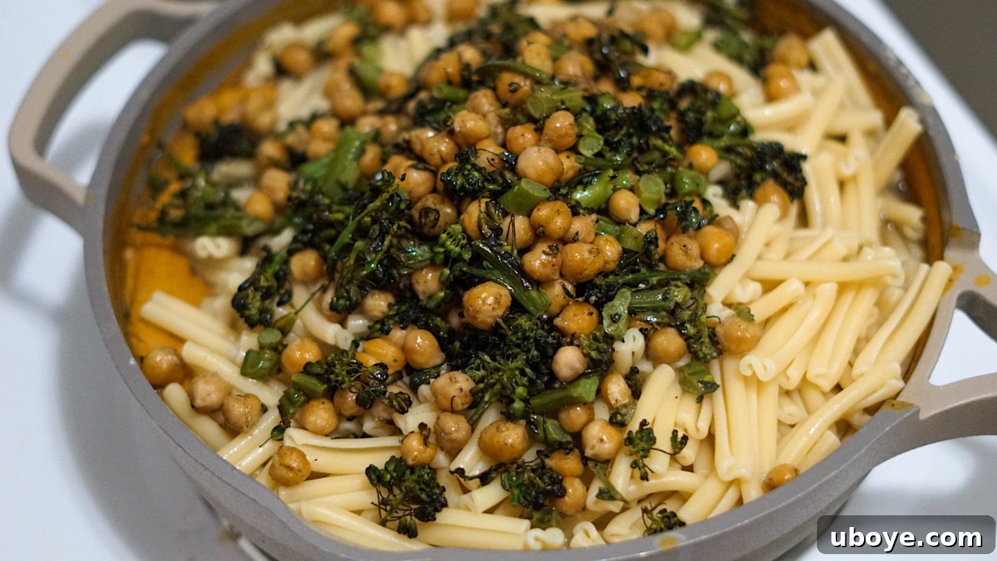Warm Spiced Pumpkin Pasta with Charred Broccolini and Crispy Chickpeas 6 A generously portioned bowl of Spicy Vegan Pumpkin Pasta, garnished with fresh herbs and vegan parmesan.