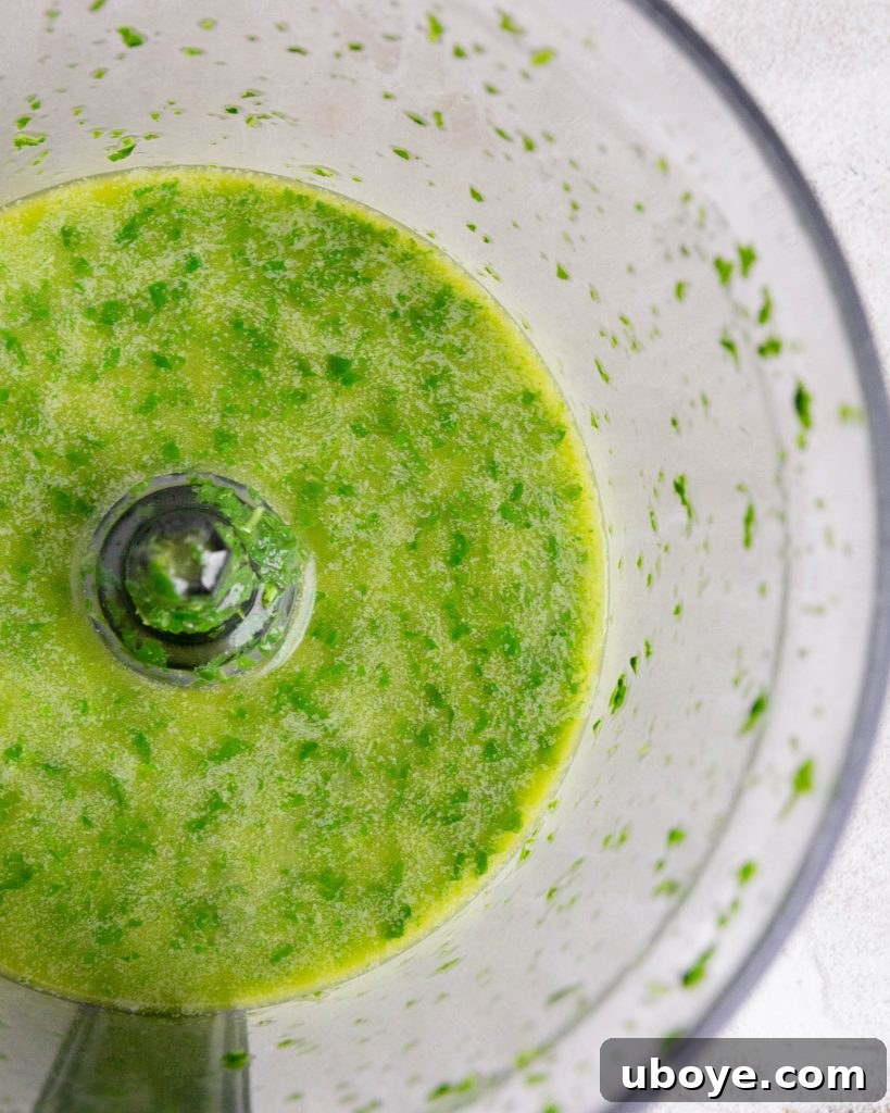 Blended basil and oil mixture being strained through cheesecloth