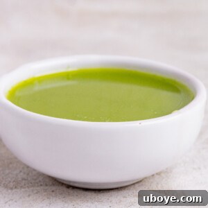 A bottle of vivid green homemade basil oil.