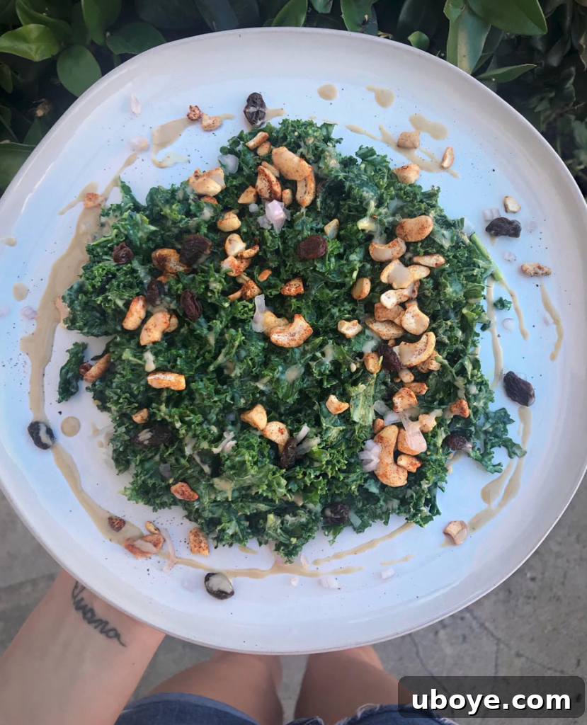 Effortless Kale Delight 2 A beautifully presented Simple Kale Salad in a bowl, showcasing the vibrant green kale, creamy tahini dressing, and scattered toppings.