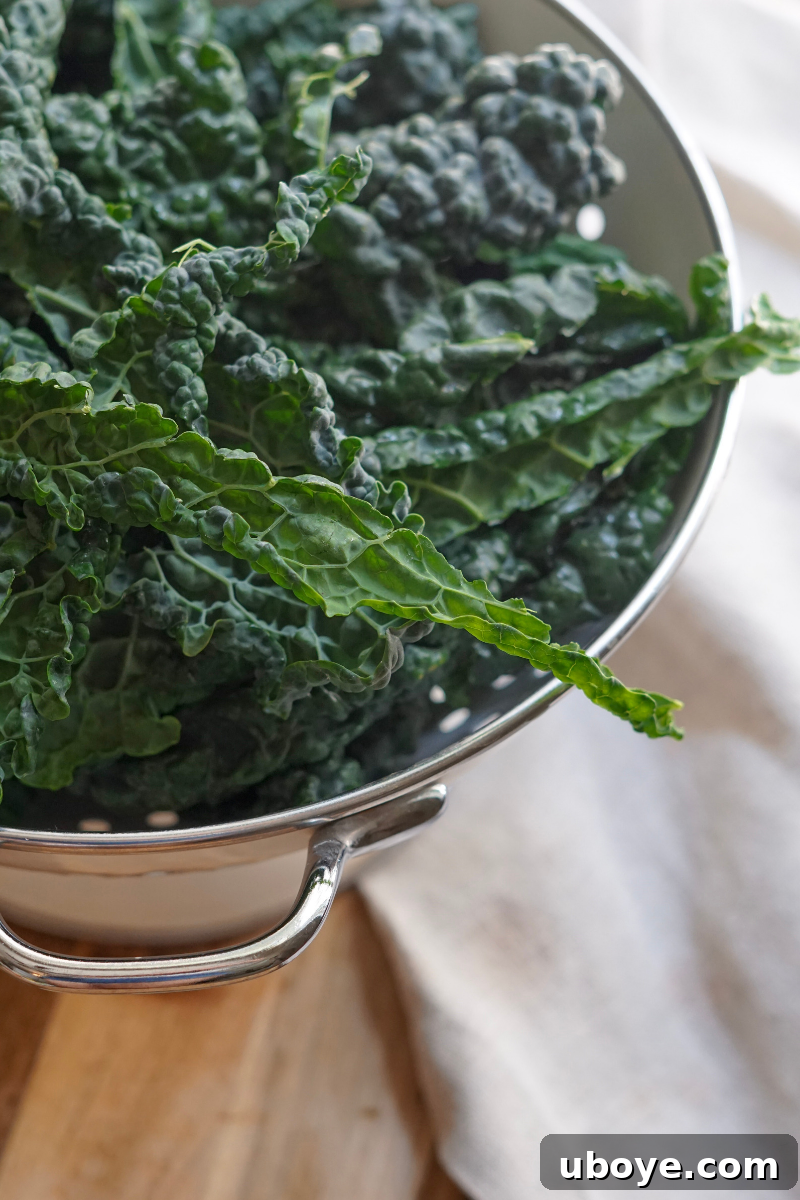 Effortless Kale Delight 3 Close-up of the kale salad with its rich, creamy tahini dressing coating the massaged kale leaves, garnished with cashews and raisins.