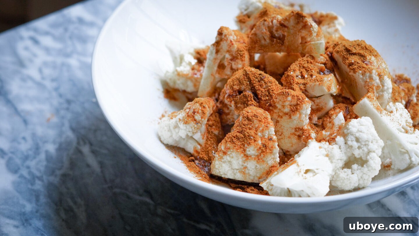 Cauliflower being seasoned with Shawarma spices and olive oil