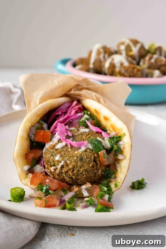 A beautifully arranged serving of falafel with tahini sauce and pickled vegetables.