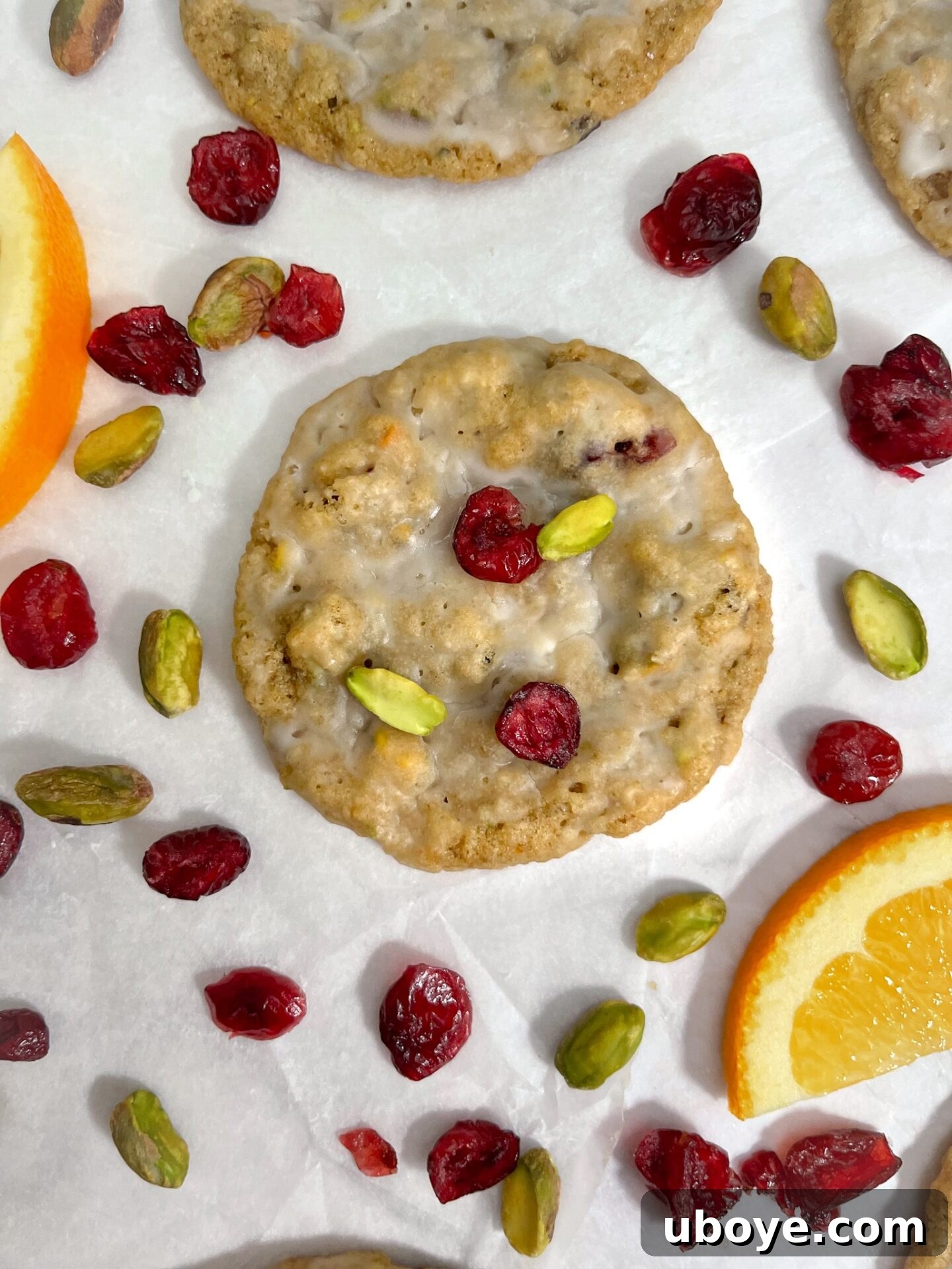 Frosted Cranberry Orange Delights 2 Freshly baked vegan iced cranberry orange oatmeal cookies on a cooling rack.