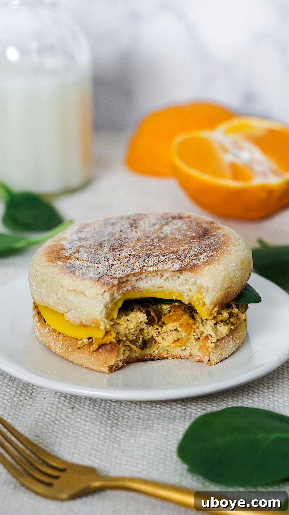 Close-up of a vegan breakfast sandwich with tofu frittata and melted cheese.
