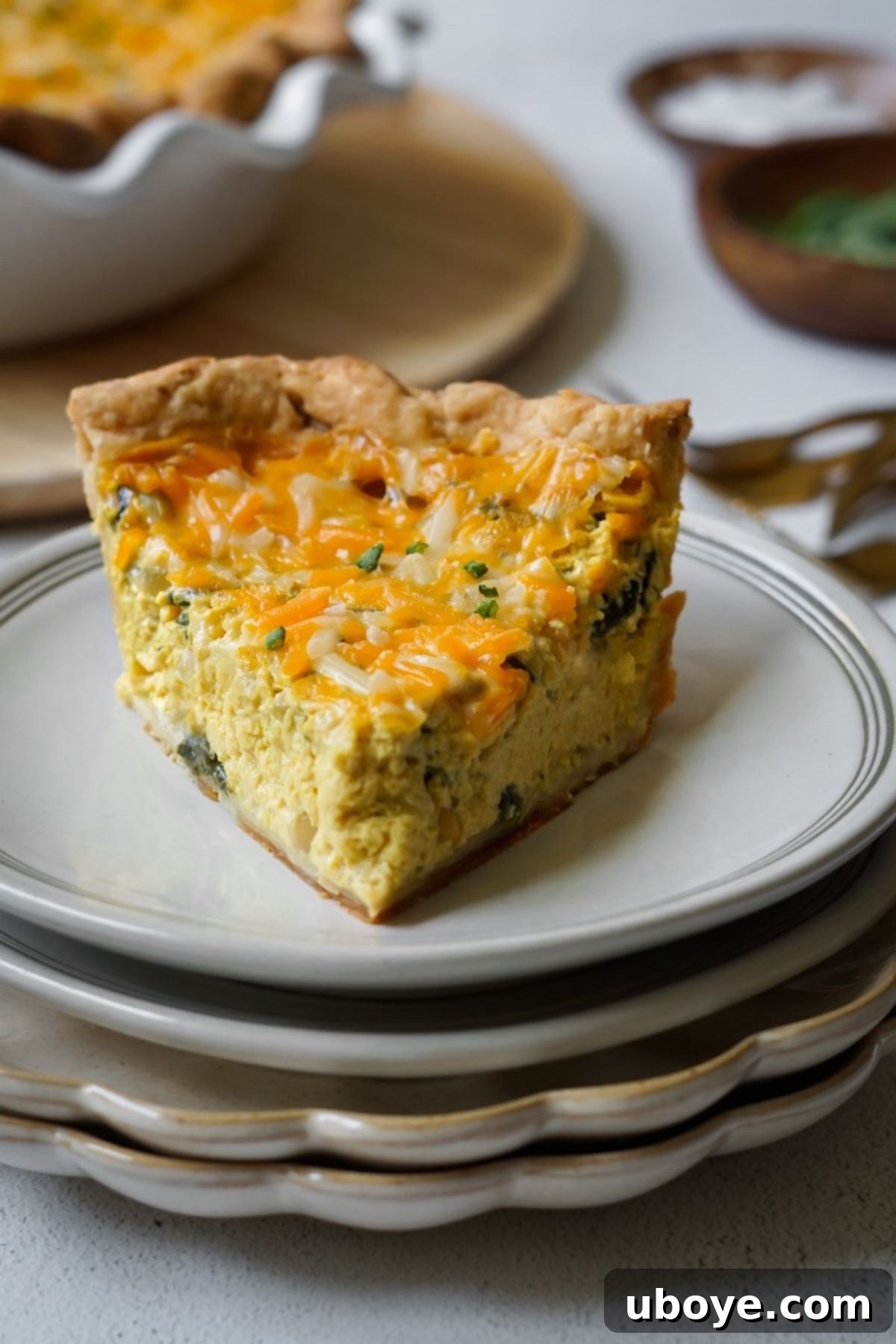 Ingredients for vegan quiche laid out on a table, including tofu, spinach, and spices