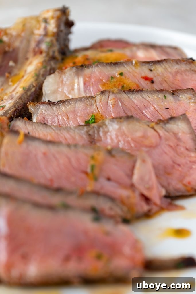 Meat thermometer inserted into a ribeye steak cooking in an oven