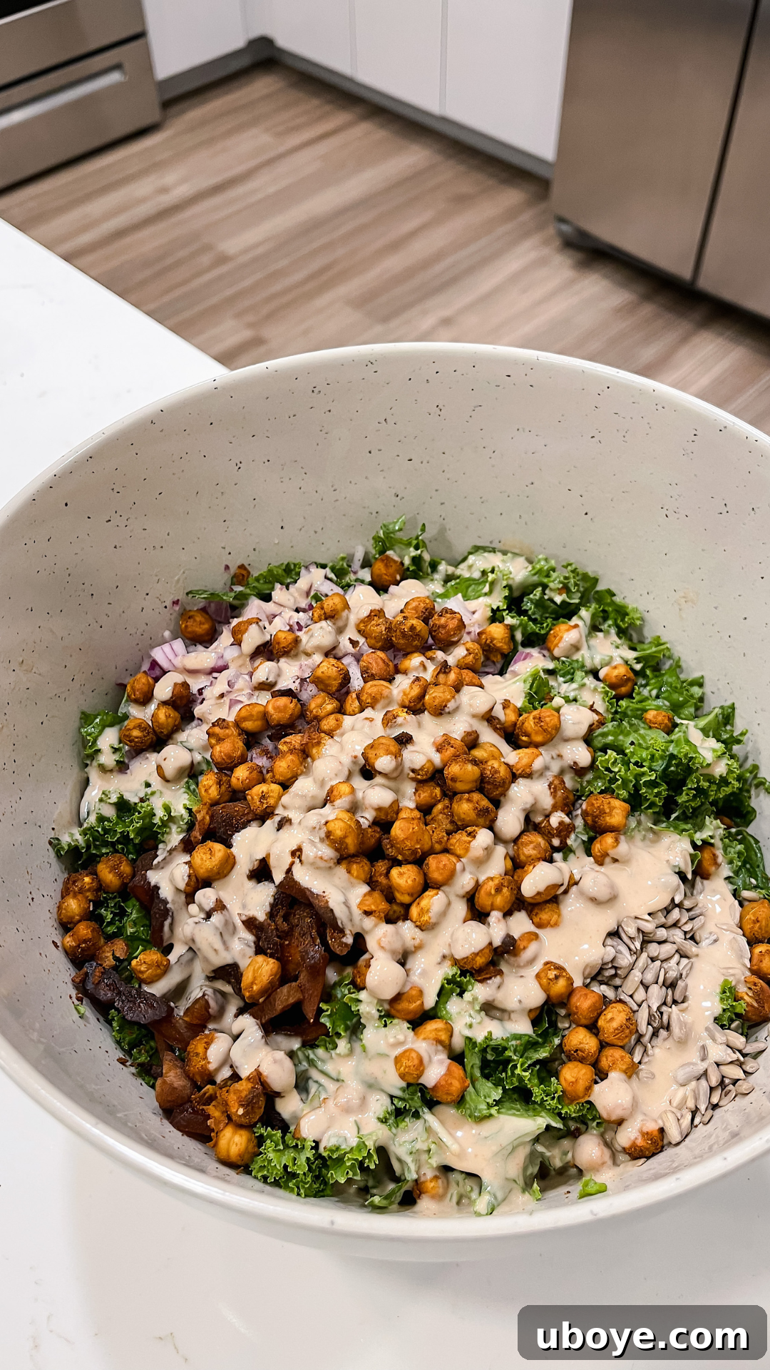 Crispy chickpeas generously topped on a fresh kale salad with a drizzle of tahini dressing.