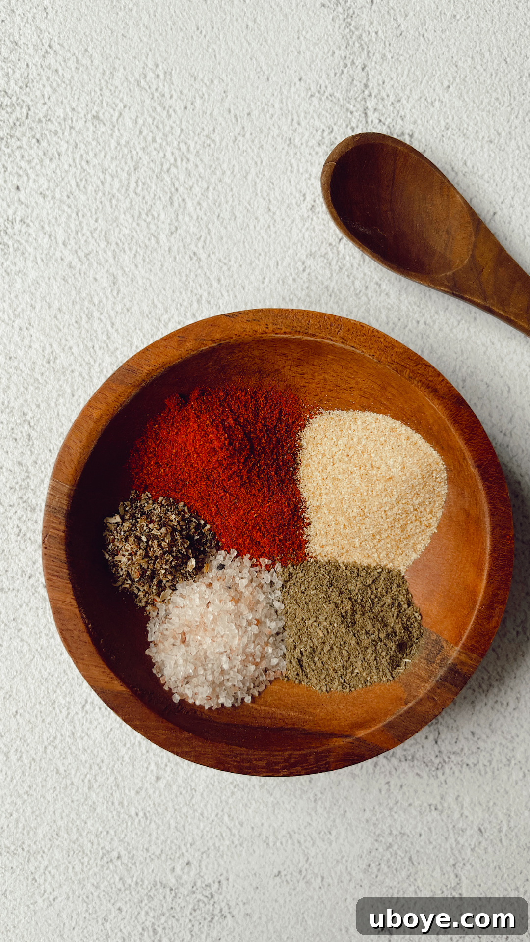 Assortment of vibrant, aromatic spices neatly arranged in a rustic wooden bowl, ready for cooking