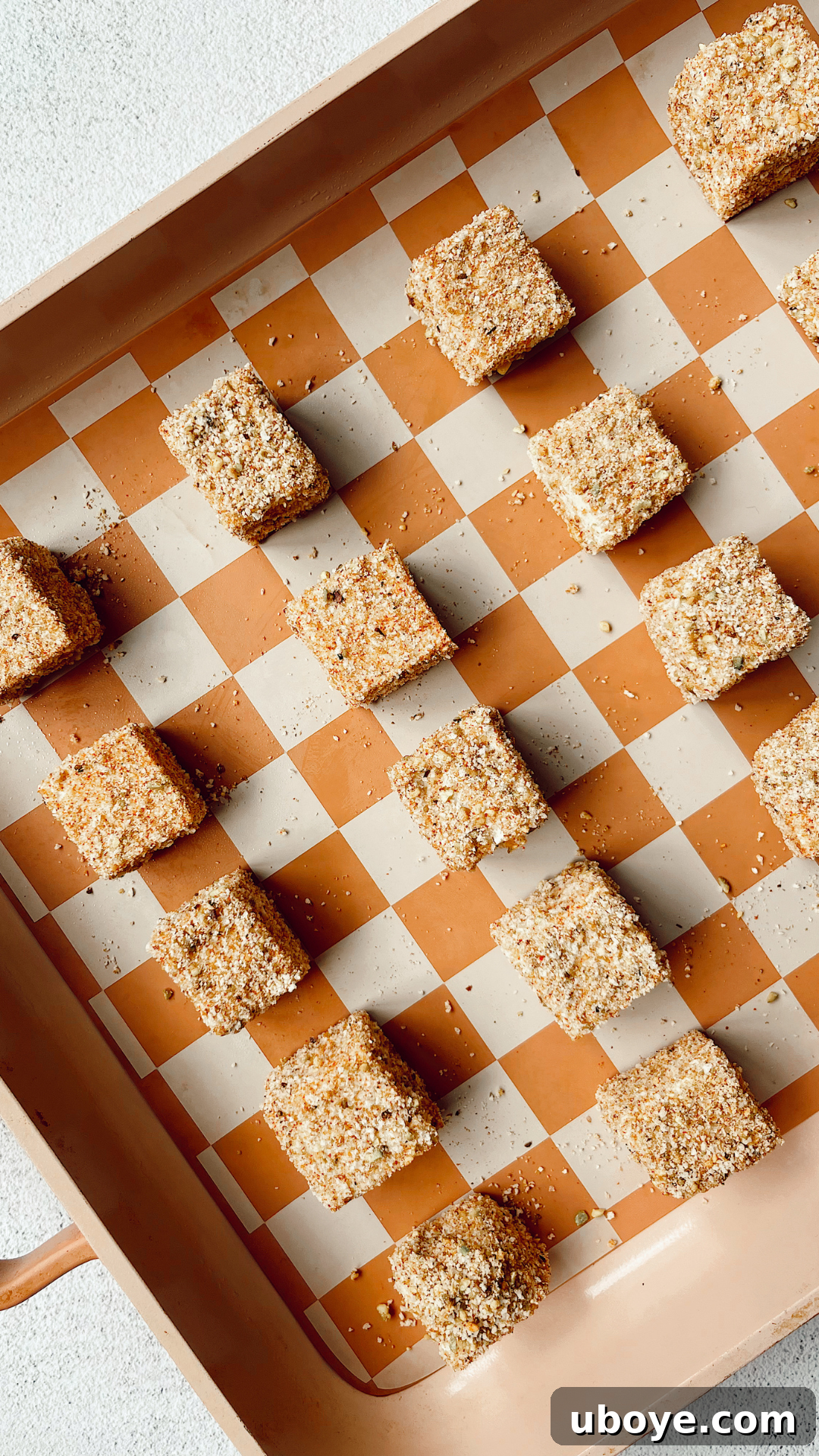 Crispy pistachio-crusted tofu nuggets baking on a lined cookie sheet, golden brown and ready to serve