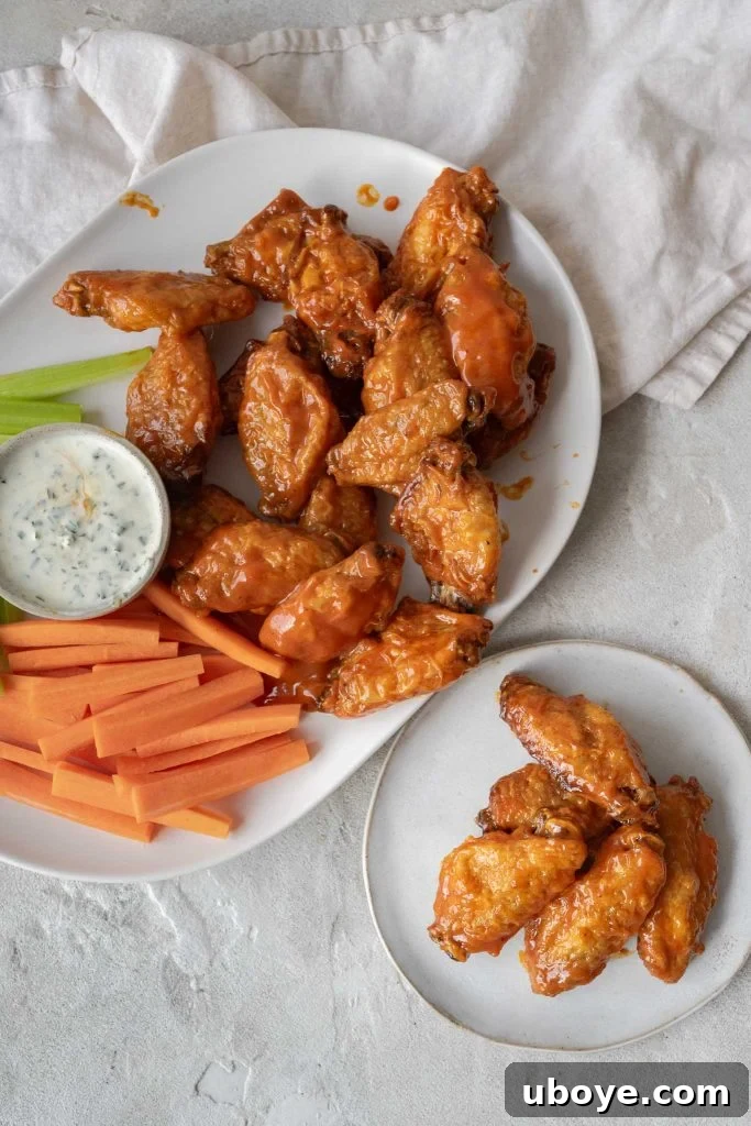 Crispy Baked Buffalo Wings 2 Crispy oven baked Buffalo wings arranged on a plate with blue cheese dip and celery sticks