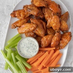 Oven baked buffalo wings in a bowl with dipping sauce