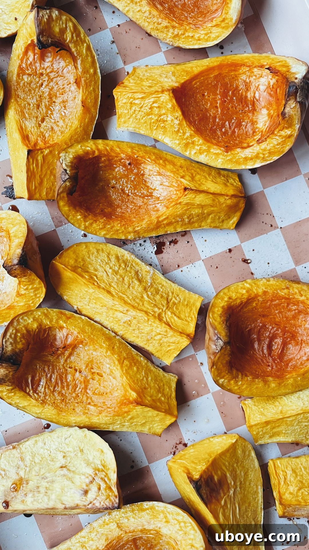 Butternut squash wedges, chopped apples, and whole garlic cloves roasting on a baking sheet, golden and tender.