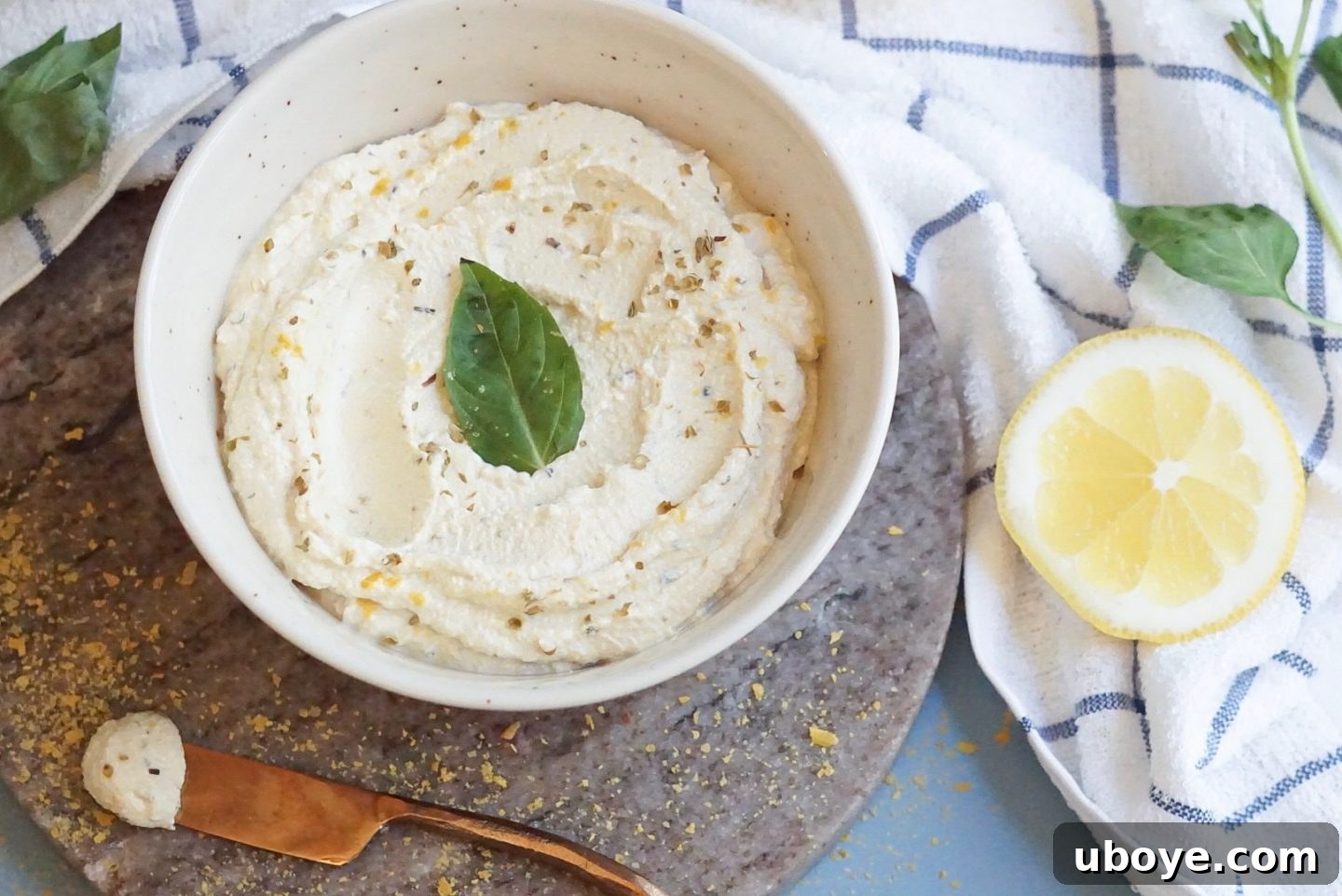 Ingredients for vegan ricotta cheese laid out on a counter, including tofu, lemon, and spices