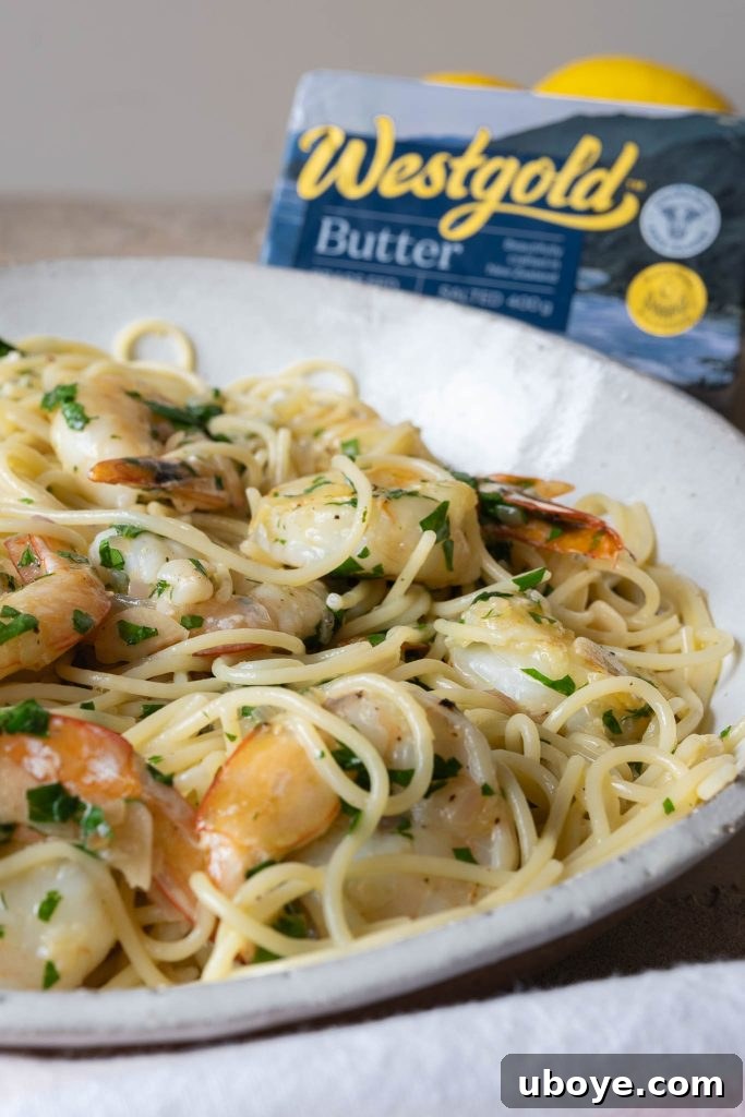 Garlic butter prawn pasta being prepared in a large pan with olive oil