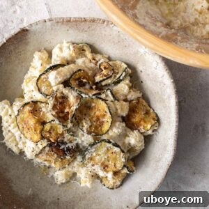 A serving of creamy lemon ricotta pasta on a plate, garnished with fresh herbs and a drizzle of olive oil, ready to be savored.