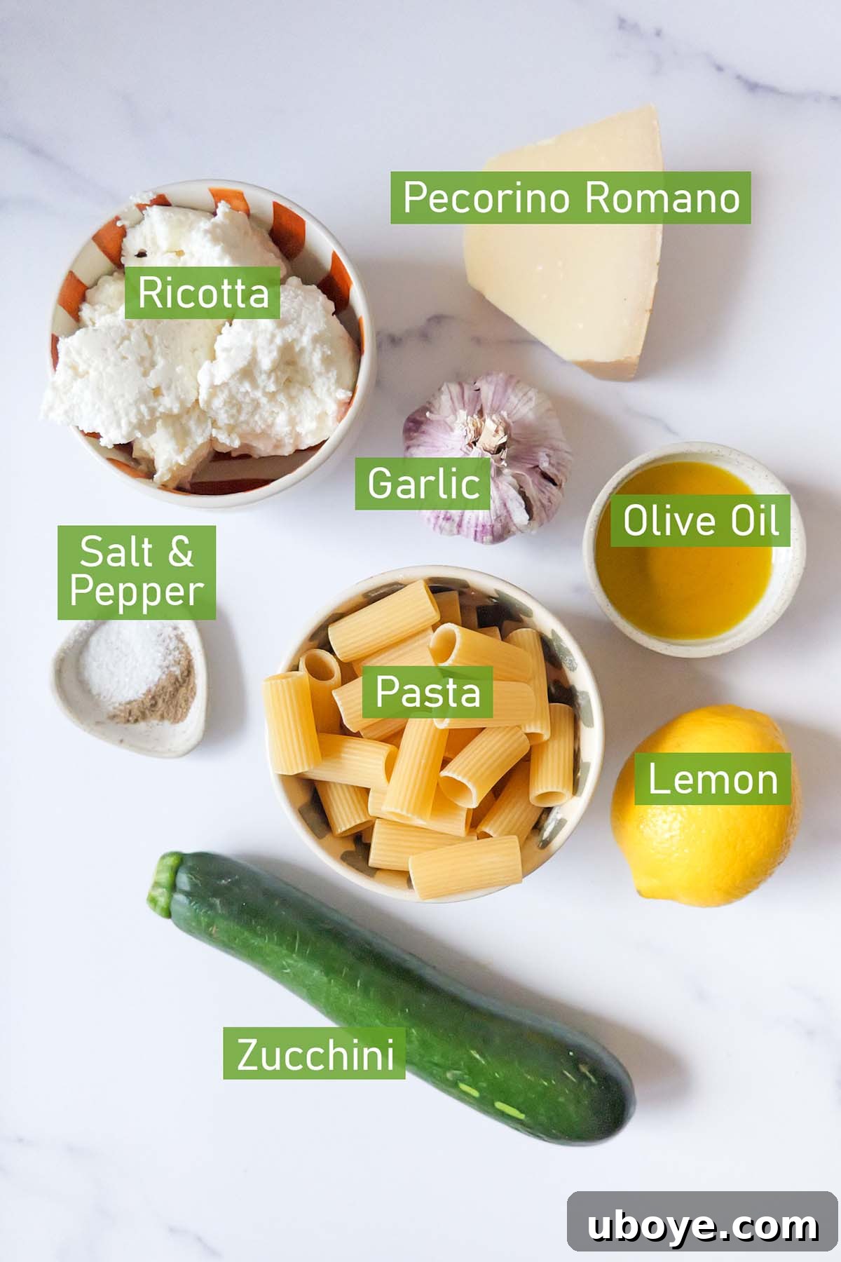 Bowls of fresh ingredients for lemon ricotta pasta, including ricotta cheese, lemons, garlic, and zucchini, neatly arranged on a kitchen counter.