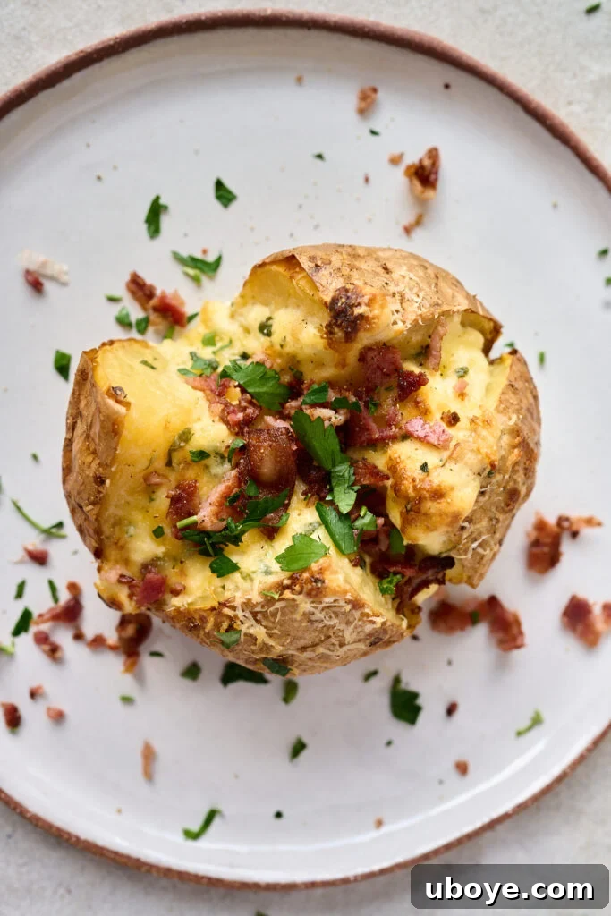 Creamy Garlic Baked Potatoes 3 Close-up of a stuffed baked potato with creamy filling and crispy toppings