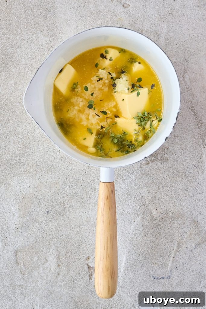 Homemade garlic butter with fresh herbs in a small saucepan