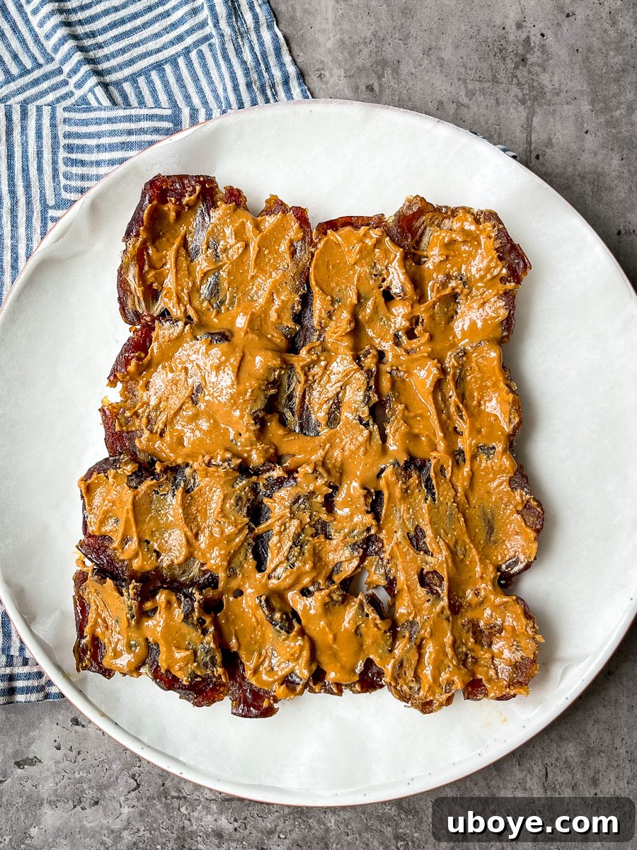 No Bake Date Bark Delight 4 Peanut butter being spread evenly over the flattened Medjool dates