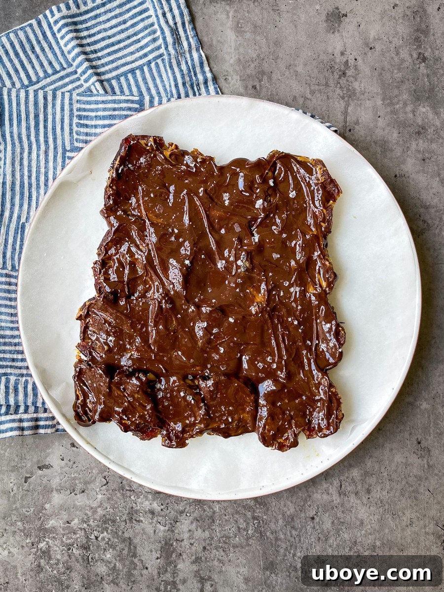 No Bake Date Bark Delight 5 Melted chocolate spread over peanut butter and dates, sprinkled with sea salt