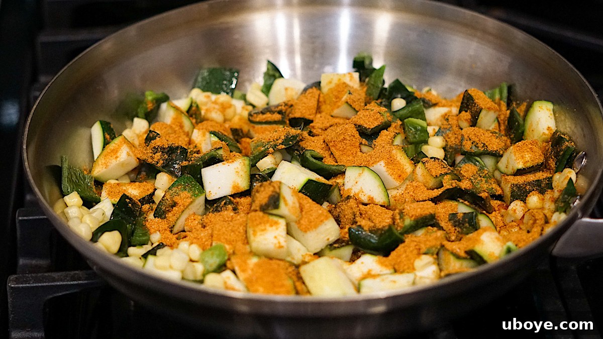 Flavor-Packed Baked Veggie Tacos 5 Chopped zucchini, poblano peppers, and corn being sautéed in a frying pan with taco seasoning.