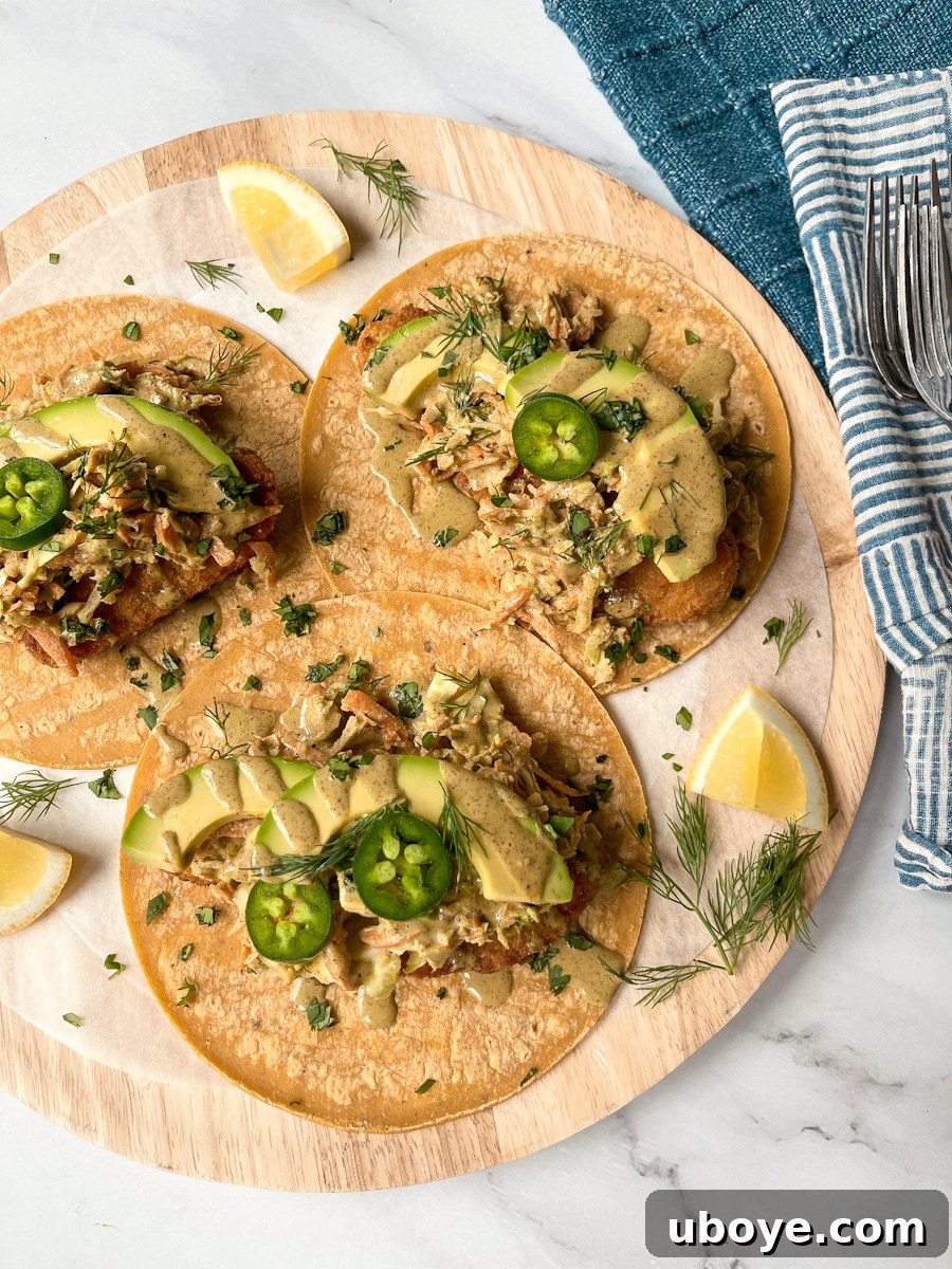 Crispy Plant-Based Chick'n Tacos with Zesty Slaw 2 Two hands holding a vibrant vegan chicken taco with slaw and a creamy sauce