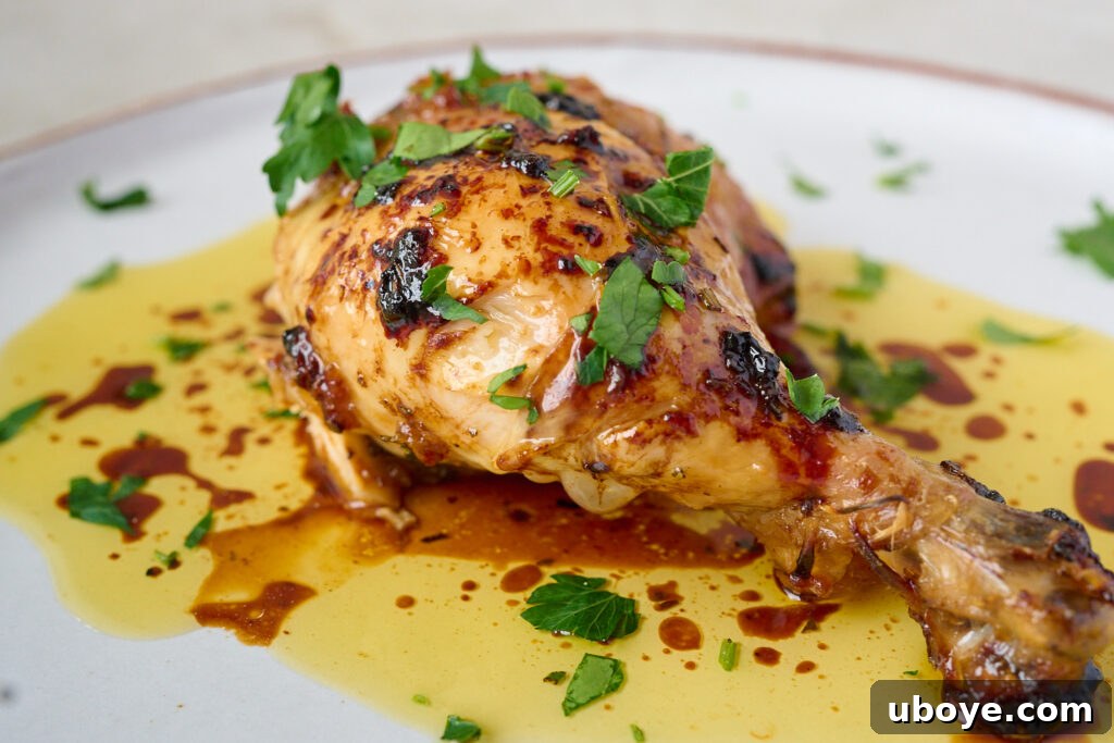 Butter-Basted Maple Roast Chicken 2 Golden brown maple butter roasted chicken with crispy skin, presented on a platter with fresh rosemary sprigs.