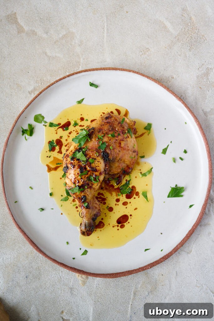 Butter-Basted Maple Roast Chicken 6 A whole maple butter roasted chicken served in a rustic platter, surrounded by herbs.