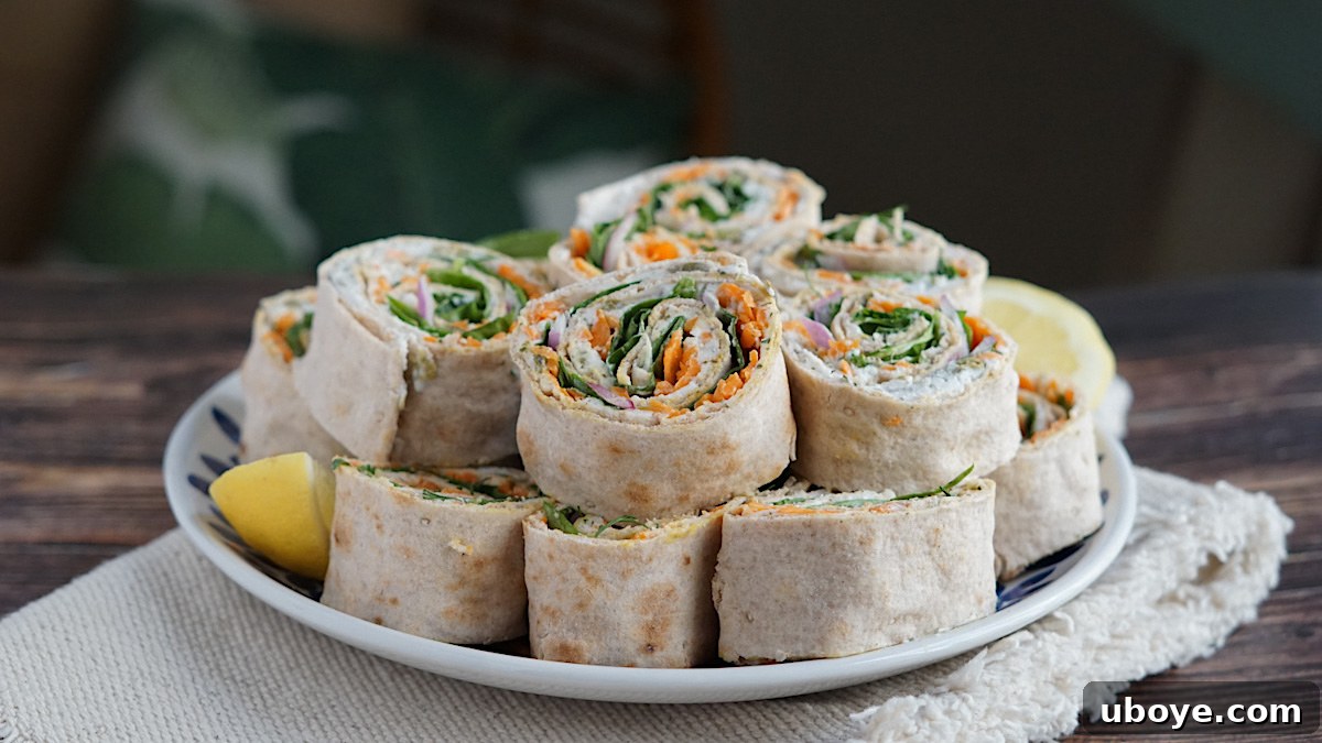 Effortless Pinwheel Creations 2 Close-up of freshly sliced vegan pinwheels on a wooden board, showcasing vibrant fillings of cream cheese, carrots, spinach, and red onion