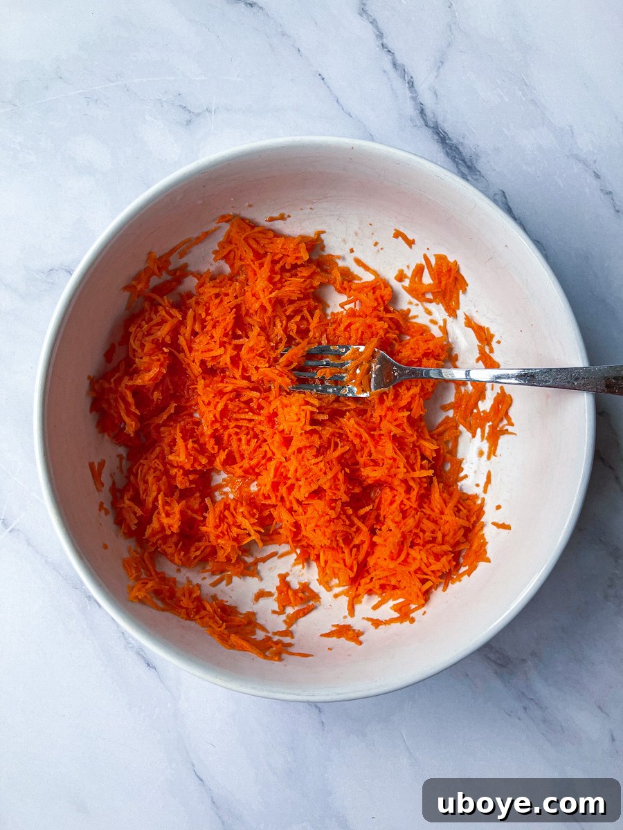 Effortless Pinwheel Creations 3 Grated carrots being mixed with lemon juice and salt in a bowl, a key step for flavorful pinwheels