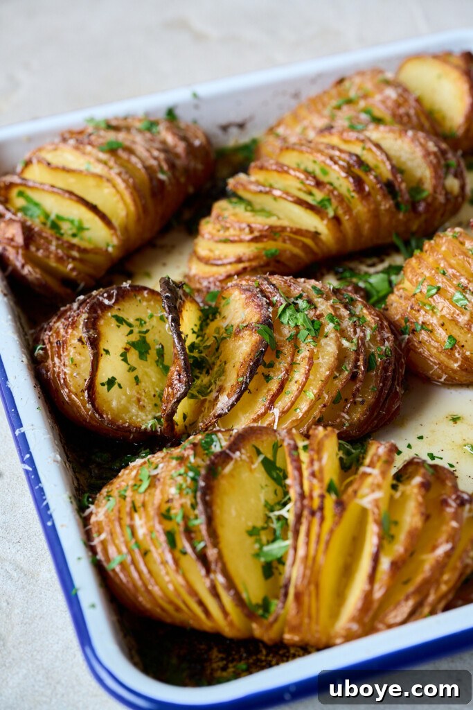 Garlic butter hasselback potatoes topped with fresh parsley and Parmesan cheese